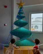 Kids at Olioli looking at a spiralChristmas Tree indoor