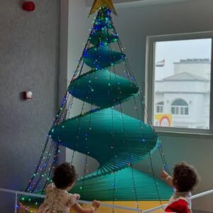 Kids at Olioli looking at a spiralChristmas Tree indoor